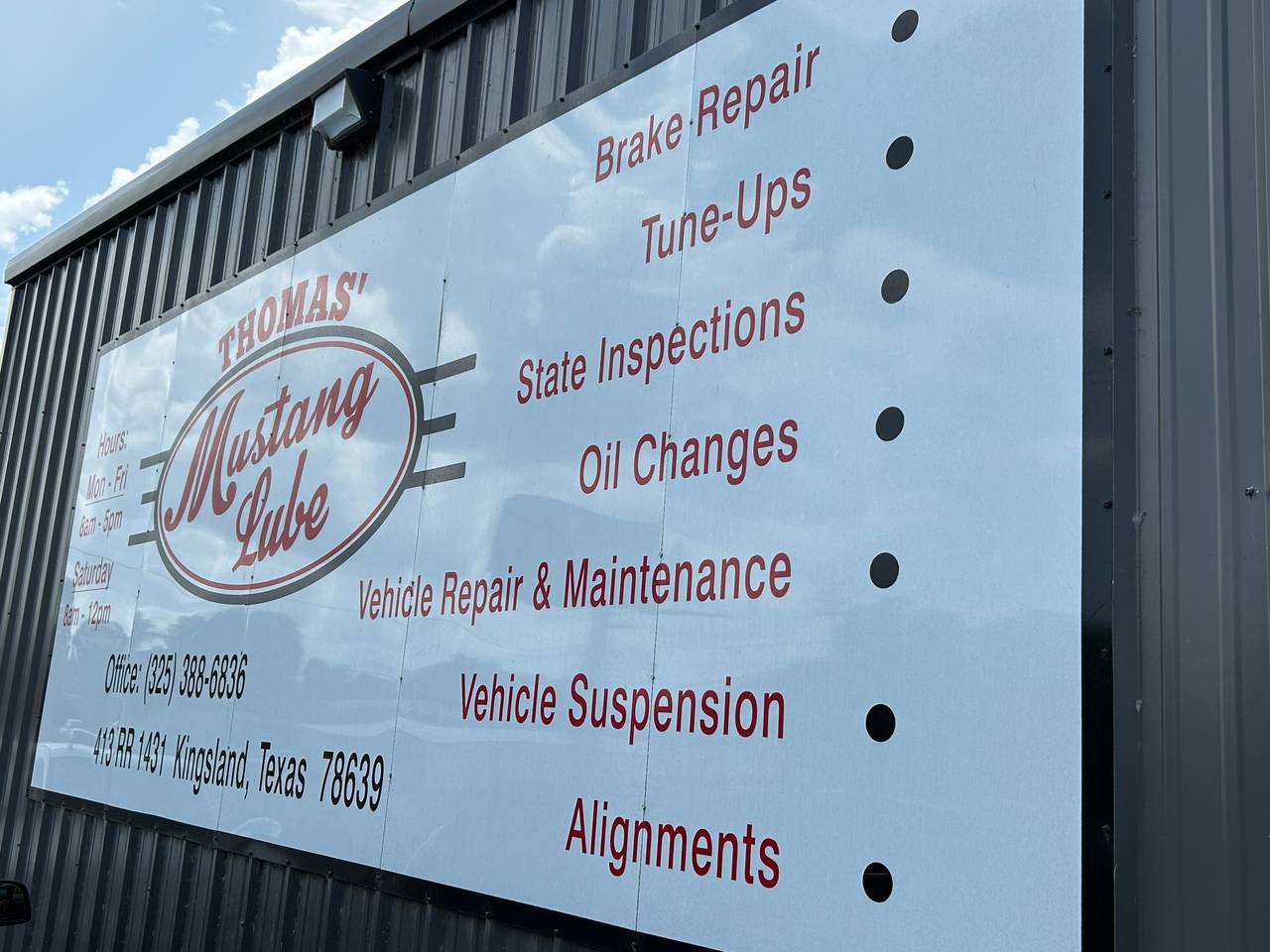 Thomas' Mustang Lube & Auto Repair shop sign listing services, hours, and address at 413 RR Hwy 1431, West Dr, Kingsland, TX